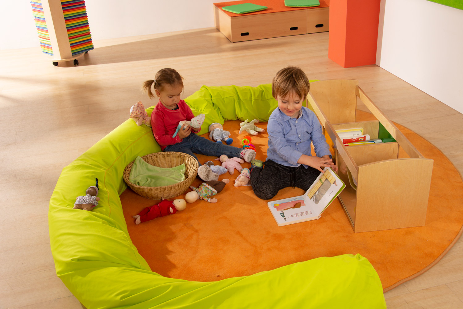 Children playing with the dolls of the Joyk Treasure Basket set in a play corner