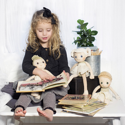 Child reading to the Rubens EcoBuds dolls from a picture book