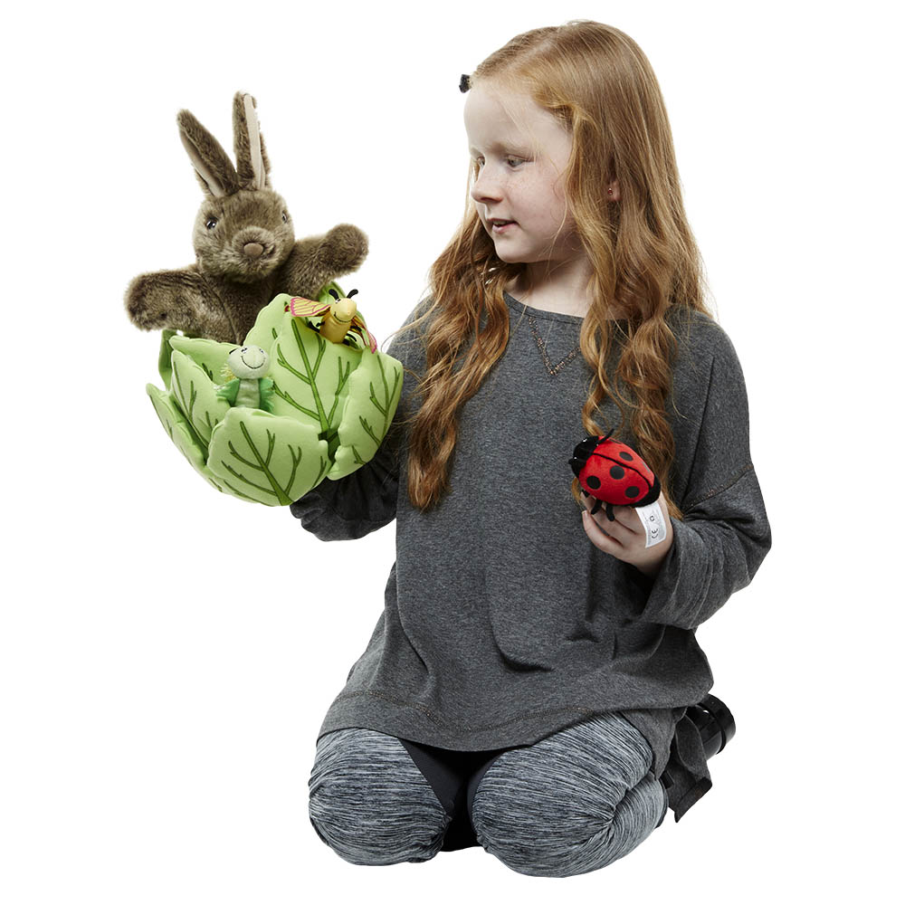 Girl holding the The Puppet Company rabbit in lettuce hand puppet and the ladybird finger puppet