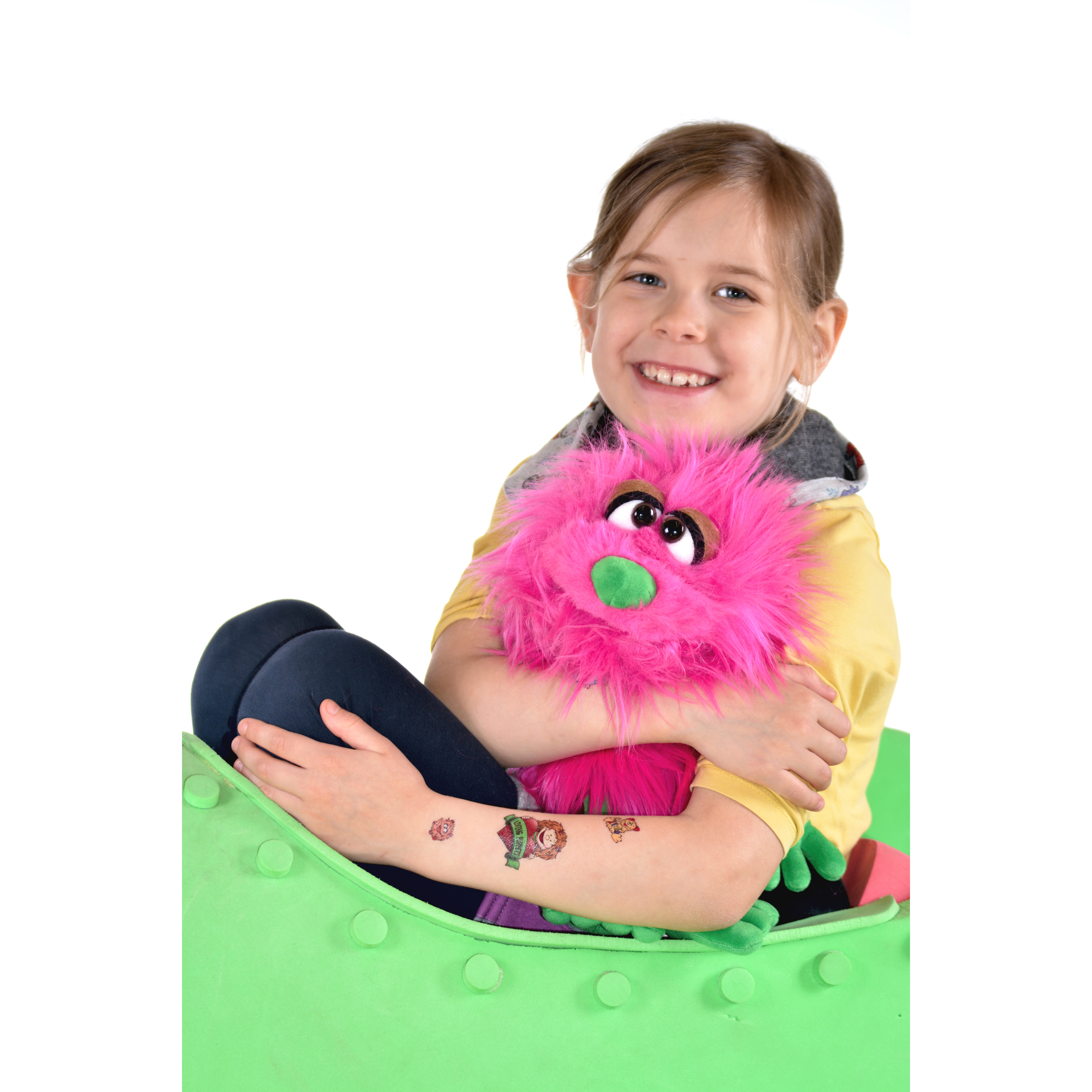 Kind mit Living Puppets Tattoos auf dem Arm umarmt eine pinke Handpuppe, Anwendungsbeispiel