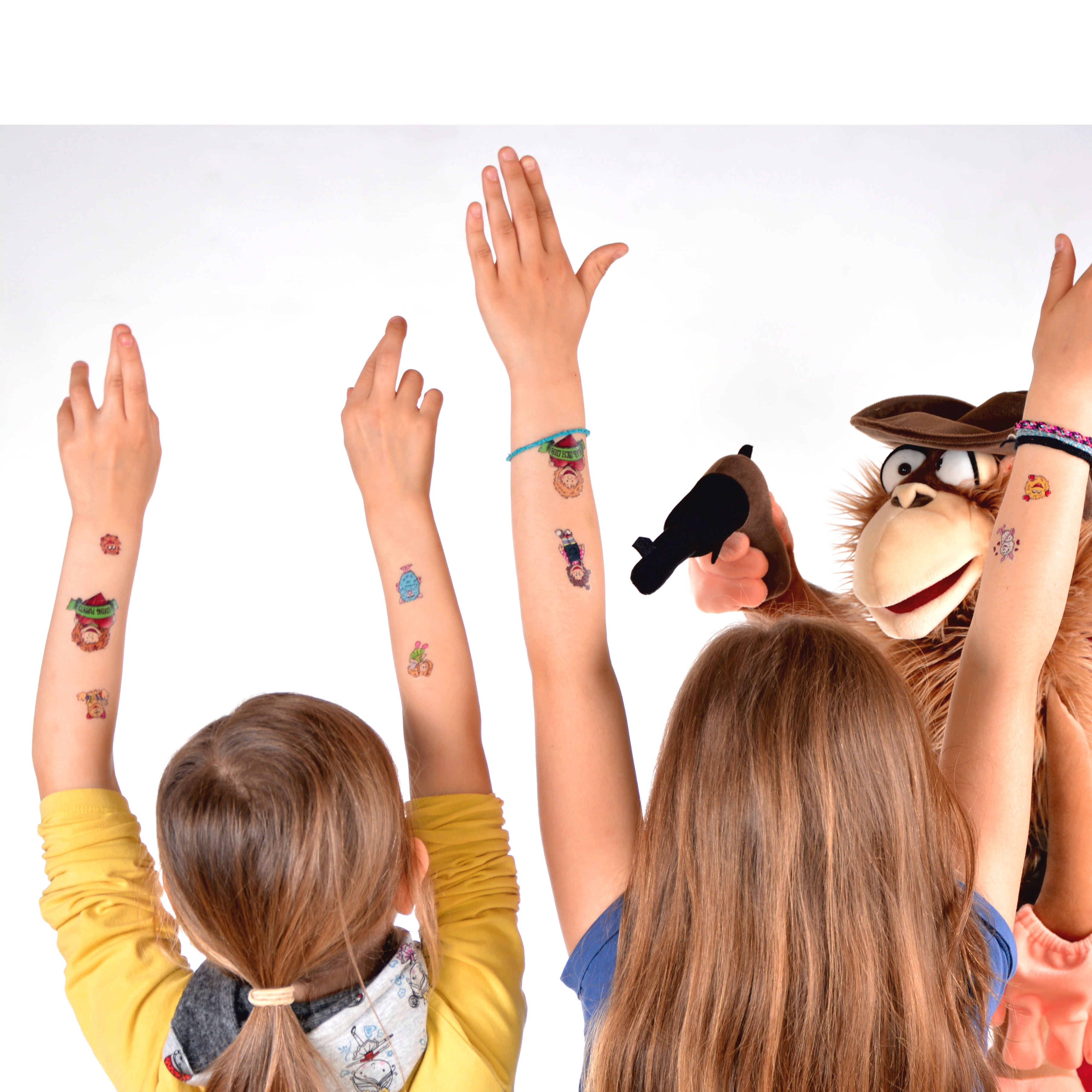Kinder strecken ihre Arme mit Living Puppets Tattoos in die Höhe, daneben eine Affen-Handpuppe, Anwendungsbeispiel