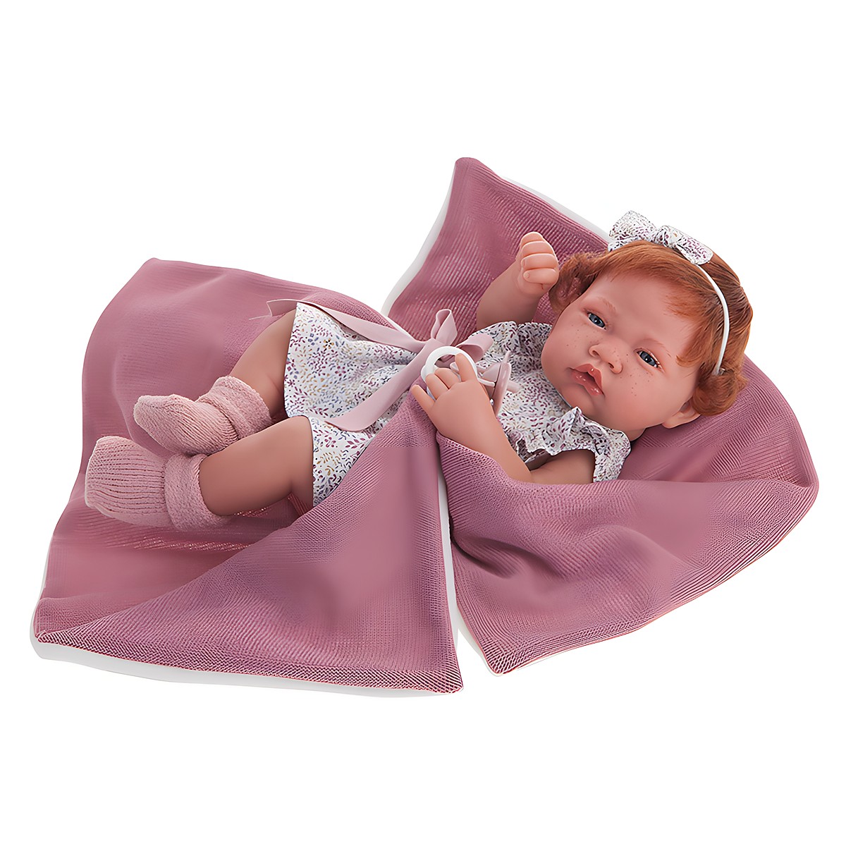 Antonio Juan baby doll New Born, realistic doll with red hair in a floral dress, wrapped in a dusty pink cuddly blanket