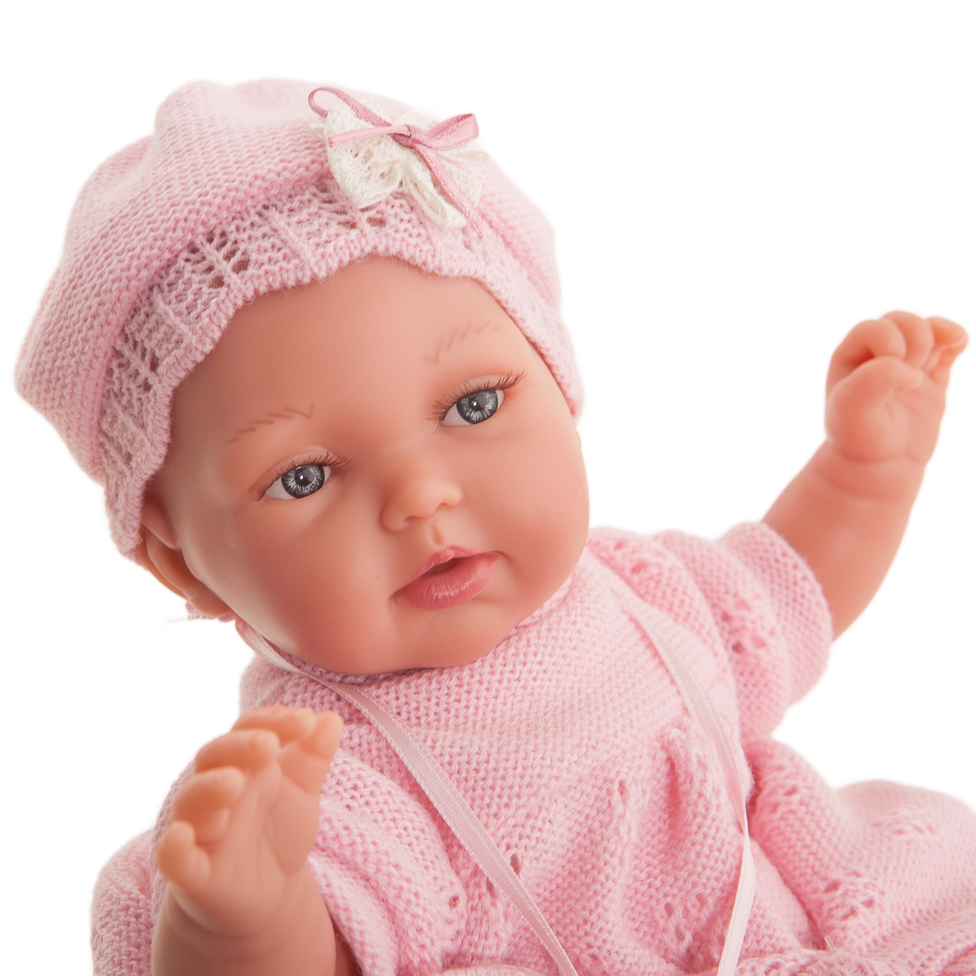 Antonio Juan baby doll Peke, close-up of the face with blue eyes and a pink crocheted bonnet with bow