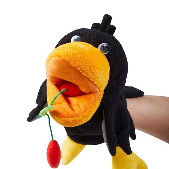 HABA Baby-Handpuppe Rabe Theo, auf dem Arm getragen mit Kirschstängel im geöffneten Schnabel