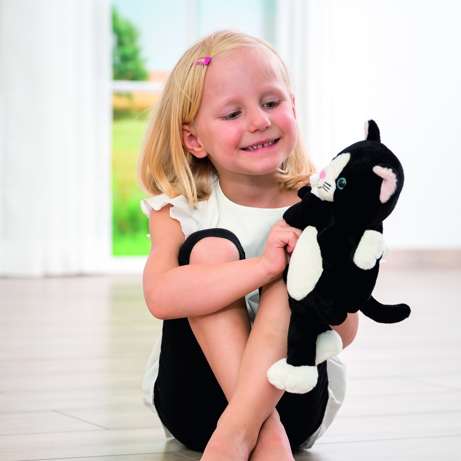 Mädchen kuschelt mit der Beleduc Geschichten-Handpuppe Katze Cara, Anwendungsbeispiel