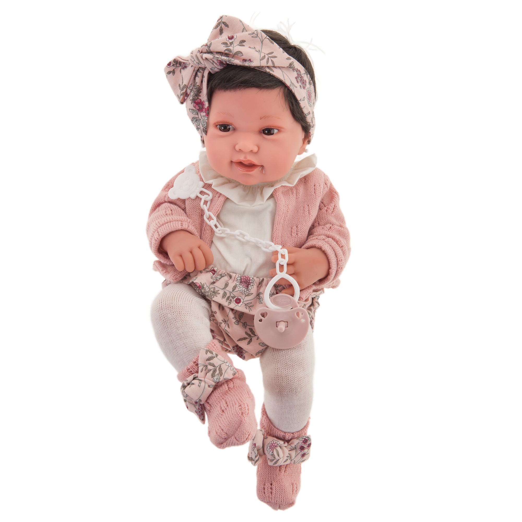 Antonio Juan baby doll Pipa, realistic doll with dark hair, floral headband and pink knit cardigan, front view with white tights