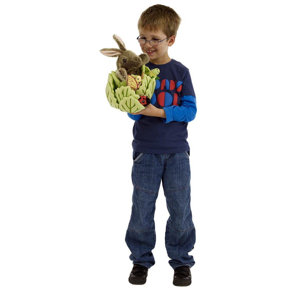 Boy in a blue sweater holding the The Puppet Company rabbit in lettuce hand puppet on his arm