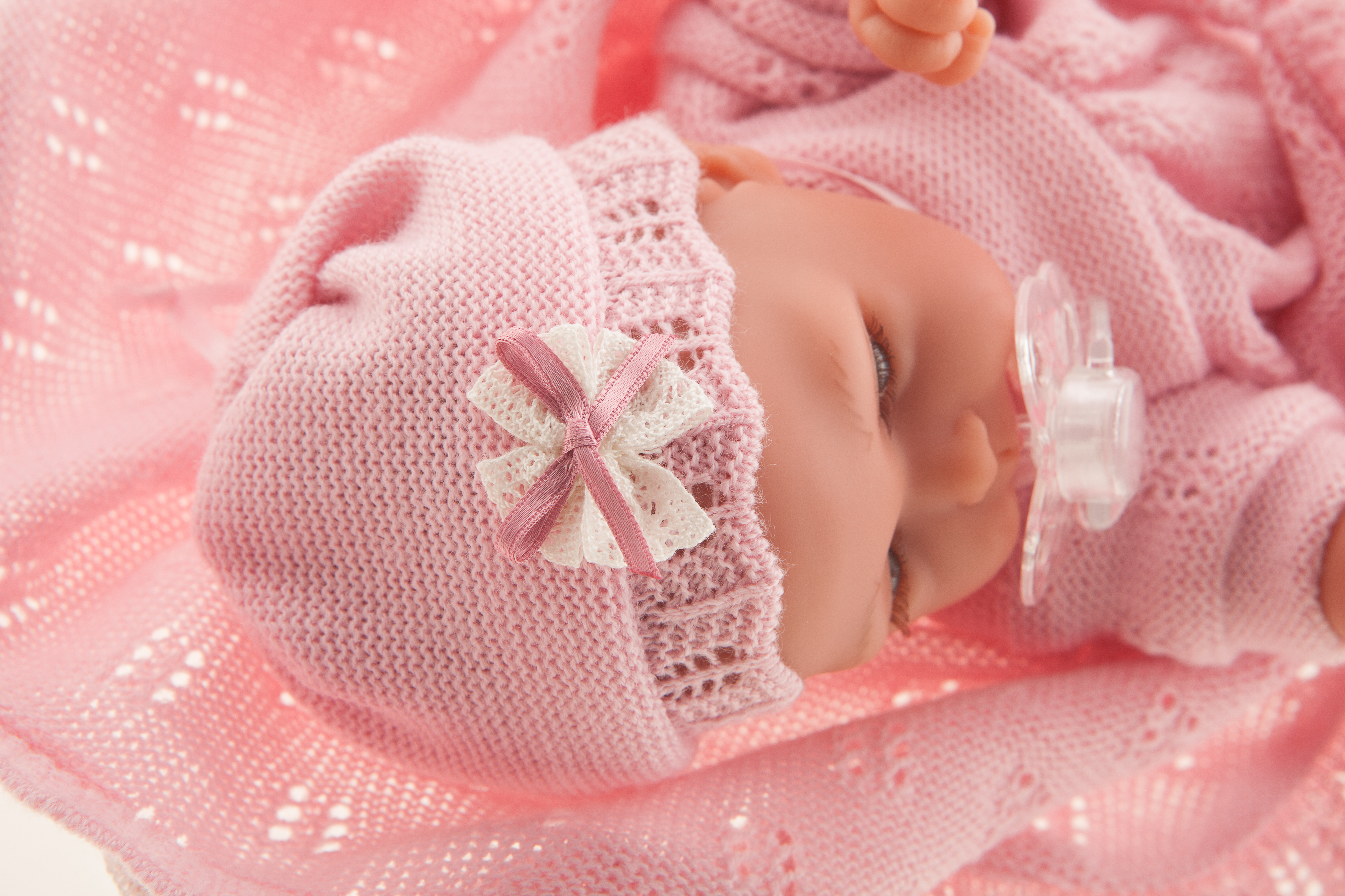 Antonio Juan baby doll Peke, sleeping face with pacifier, pink bow bonnet, wrapped in the cuddly blanket