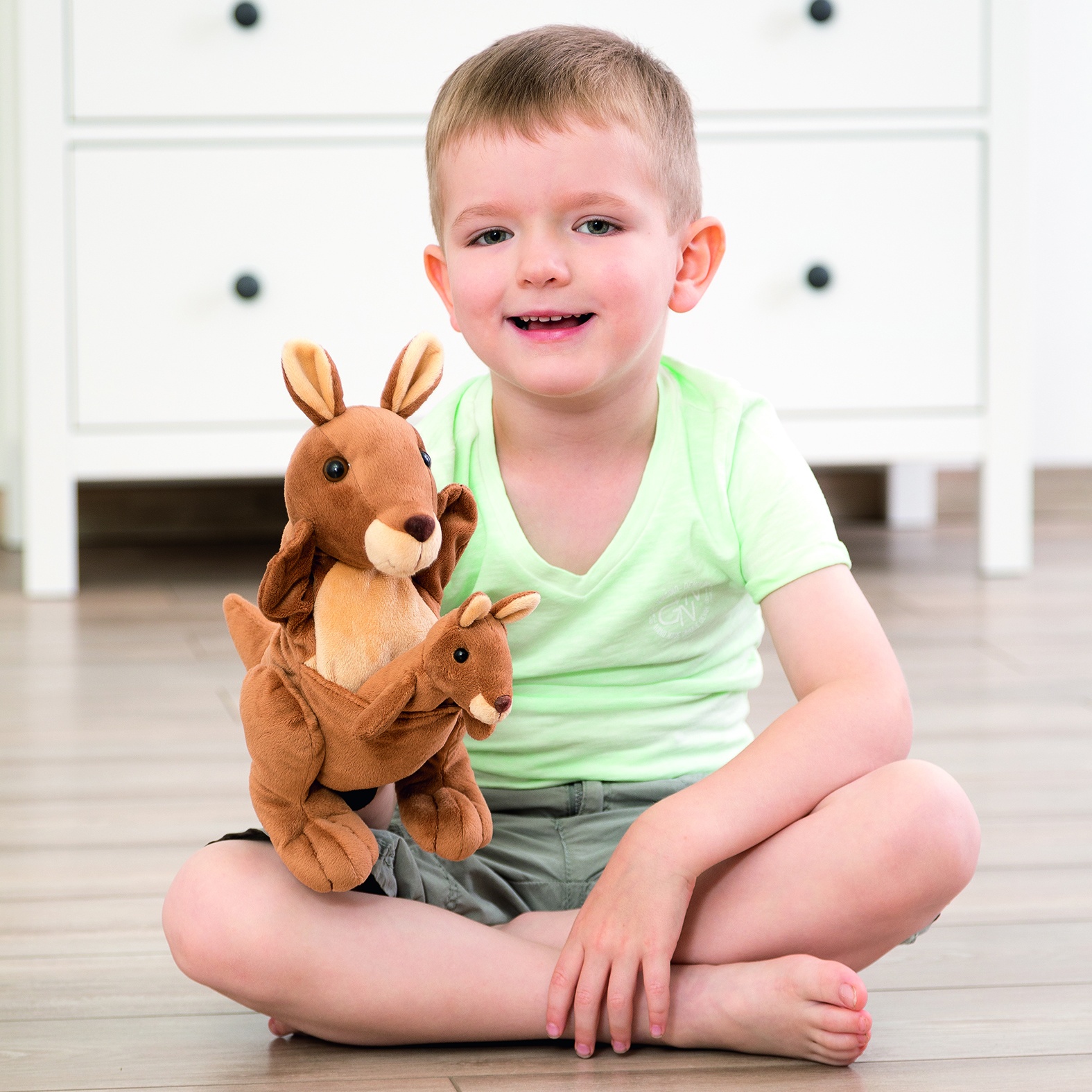 Boy sitting with the Beleduc story hand puppet kangaroo Kanga and finger puppet Juju, usage example